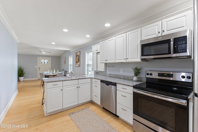 2415 Circle St, Wilmington, NC 28403 - kitchen with stainless steel appliances, a peninsula, a sink, baseboards, and recessed lighting