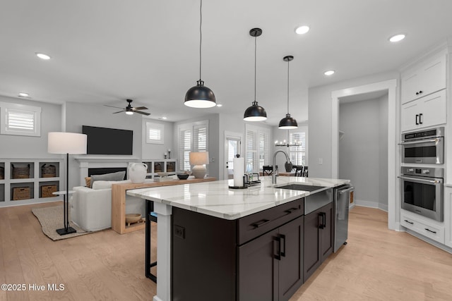 3625 Mason Port Dr, Wilmington, NC 28409 - kitchen with a sink, appliances with stainless steel finishes, ceiling fan, light wood finished floors, and white cabinets