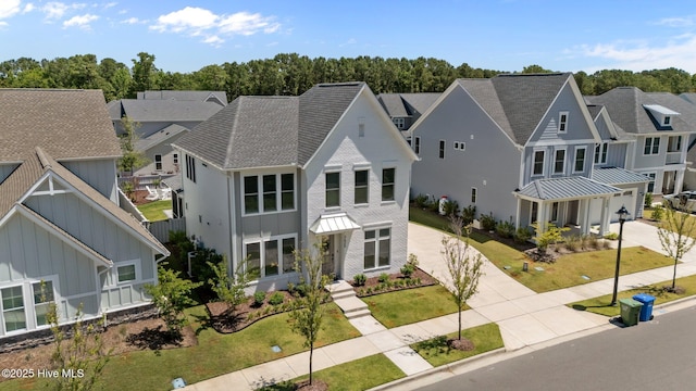 3625 Mason Port Dr, Wilmington, NC 28409 - view of front facade with concrete driveway, a residential view, a standing seam roof, and a front lawn