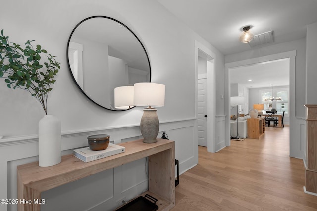 3625 Mason Port Dr, Wilmington, NC 28409 - corridor featuring light wood-type flooring, a wainscoted wall, and a chandelier