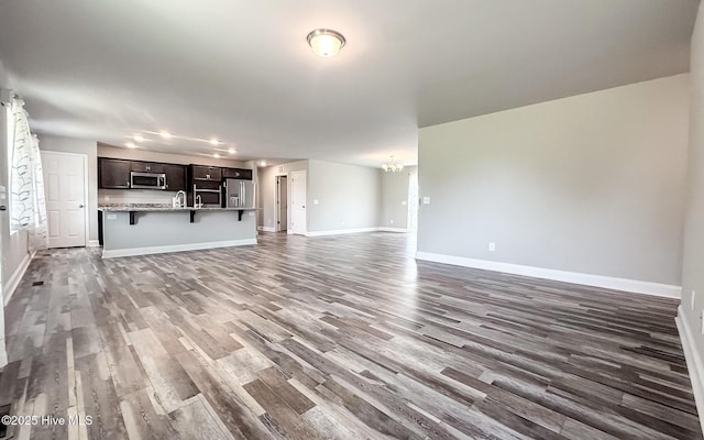126 Vick Ave, Carthage, NC 28327 - unfurnished living room with wood finished floors, baseboards, and a sink