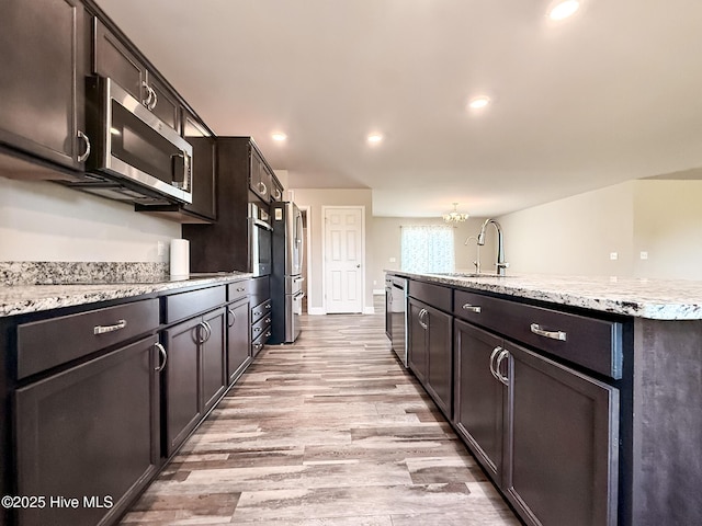 126 Vick Ave, Carthage, NC 28327 - kitchen with appliances with stainless steel finishes, a sink, light wood finished floors, a chandelier, and recessed lighting