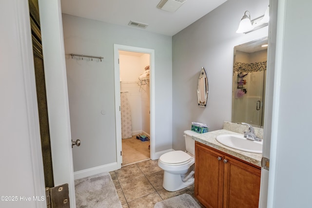 2003 Riverview Ln, Morehead City, NC 28557 - bathroom featuring a walk in closet, vanity, a shower, toilet, and tile patterned flooring