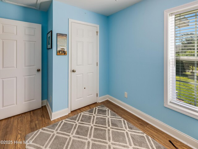 2003 Riverview Ln, Morehead City, NC 28557 - unfurnished bedroom with baseboards, wood finished floors, and multiple windows