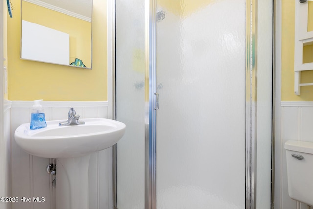 301 E Commerce Way Unit 350, Atlantic Beach, NC 28512 - bathroom with a wainscoted wall, a shower stall, a decorative wall, crown molding, and toilet