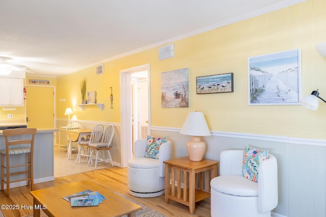 301 E Commerce Way Unit 350, Atlantic Beach, NC 28512 - living room featuring light wood finished floors, crown molding, and a wainscoted wall