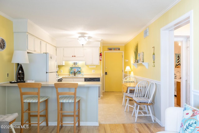 301 E Commerce Way Unit 350, Atlantic Beach, NC 28512 - kitchen with freestanding refrigerator, light countertops, ornamental molding, a peninsula, and white cabinetry