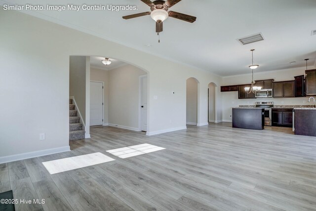 129 Tides End Dr Lot 34, Holly Ridge, NC 28445 - unfurnished living room featuring a ceiling fan, arched walkways, ornamental molding, a chandelier, and light wood-style floors