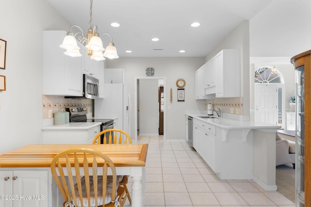 4156 Buckingham Ct, Southport, NC 28461 - kitchen featuring appliances with stainless steel finishes, a sink, a chandelier, decorative backsplash, and light countertops