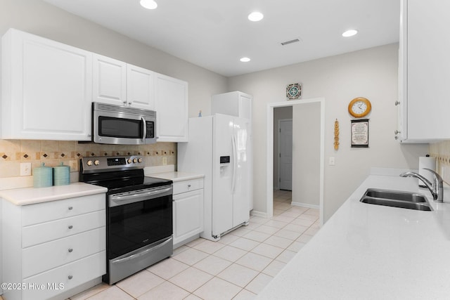 4156 Buckingham Ct, Southport, NC 28461 - kitchen with stainless steel appliances, a sink, decorative backsplash, light tile patterned flooring, and light countertops