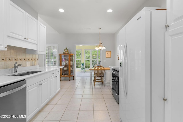 4156 Buckingham Ct, Southport, NC 28461 - kitchen with stainless steel appliances, a sink, light countertops, light tile patterned floors, and backsplash
