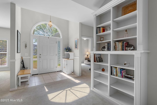 4156 Buckingham Ct, Southport, NC 28461 - foyer with light colored carpet, light tile patterned flooring, and a chandelier
