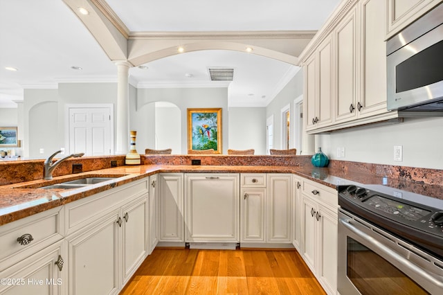 1510 N Shore Dr, Sunset Beach, NC 28468 - kitchen with stainless steel appliances, ornamental molding, dark stone counters, recessed lighting, and light wood-type flooring