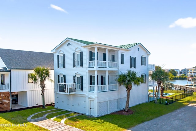 1510 N Shore Dr, Sunset Beach, NC 28468 - view of front of house featuring a balcony, a metal roof, a standing seam roof, and a water view