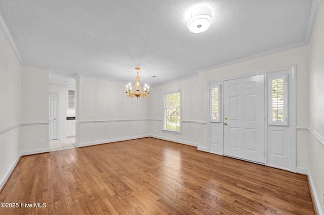 809 Greenbriar Rd, Kinston, NC 28501 - entryway featuring a textured ceiling, a chandelier, wood finished floors, ornamental molding, and baseboards