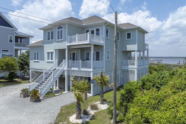 601 New River Inlet Rd, North Topsail Beach, NC 28460 - back of property with a balcony, gravel driveway, and roof with shingles