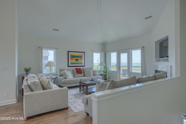 601 New River Inlet Rd, North Topsail Beach, NC 28460 - living area with lofted ceiling, wood finished floors, baseboards, and a fireplace