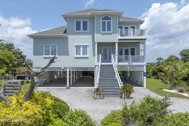 601 New River Inlet Rd, North Topsail Beach, NC 28460 - rear view of house with a carport, stairs, a balcony, gravel driveway, and a shingled roof