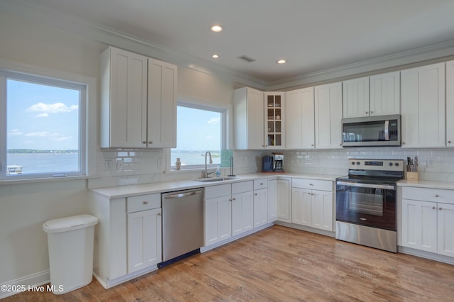 601 New River Inlet Rd, North Topsail Beach, NC 28460 - kitchen featuring stainless steel appliances, a sink, ornamental molding, tasteful backsplash, and light countertops