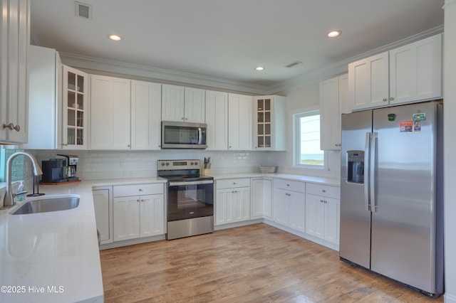 601 New River Inlet Rd, North Topsail Beach, NC 28460 - kitchen with appliances with stainless steel finishes, a sink, tasteful backsplash, light countertops, and glass insert cabinets