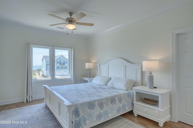 601 New River Inlet Rd, North Topsail Beach, NC 28460 - bedroom with crown molding, wood finished floors, a ceiling fan, and baseboards