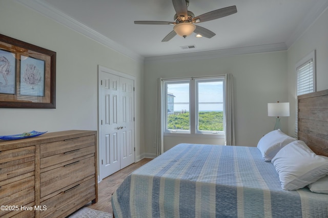 601 New River Inlet Rd, North Topsail Beach, NC 28460 - bedroom with multiple windows, light wood-style floors, crown molding, ceiling fan, and baseboards