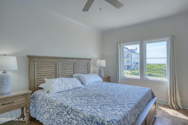 601 New River Inlet Rd, North Topsail Beach, NC 28460 - bedroom with wood finished floors, ornamental molding, baseboards, and ceiling fan