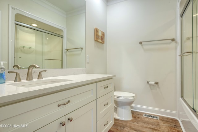 601 New River Inlet Rd, North Topsail Beach, NC 28460 - bathroom with crown molding, toilet, vanity, baseboards, and wood finished floors