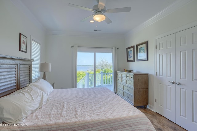 601 New River Inlet Rd, North Topsail Beach, NC 28460 - bedroom with multiple windows, ornamental molding, wood finished floors, a closet, and a ceiling fan