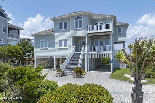 601 New River Inlet Rd, North Topsail Beach, NC 28460 - view of front of house featuring stairs, a carport, a shingled roof, and a balcony