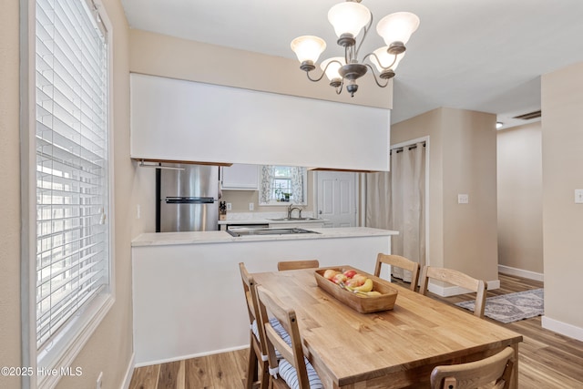 102 Oakwood Ln, Elizabeth City, NC 27909 - dining space with a chandelier, light wood-type flooring, and baseboards