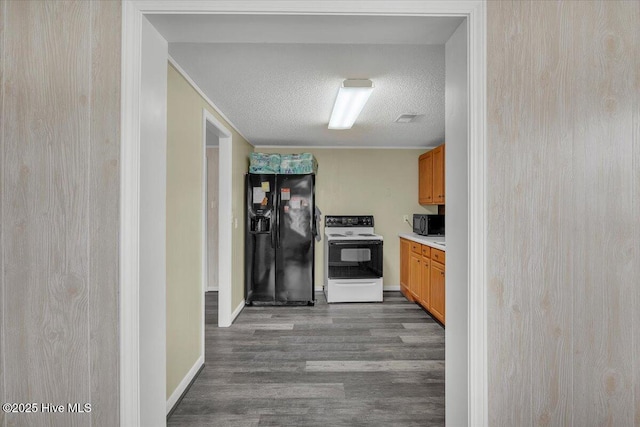 3331 Holden Beach Rd SW, Supply, NC 28462 - kitchen with black appliances, dark wood-type flooring, light countertops, a textured ceiling, and baseboards