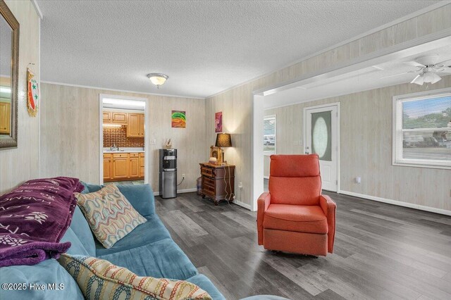 3331 Holden Beach Rd SW, Supply, NC 28462 - living room with dark wood-style floors, wood walls, a textured ceiling, baseboards, and ceiling fan