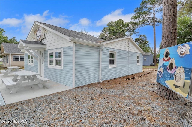 3331 Holden Beach Rd SW, Supply, NC 28462 - view of property exterior with a patio area and roof with shingles