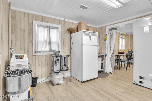 3331 Holden Beach Rd SW, Supply, NC 28462 - kitchen with freestanding refrigerator, wooden walls, wood finished floors, fridge, and crown molding