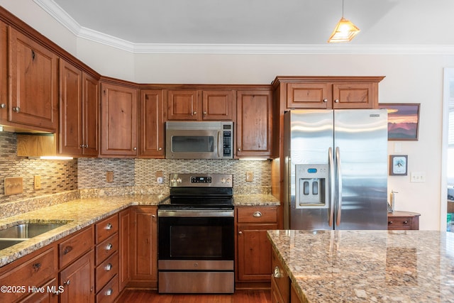 700 S 3rd St, Wilmington, NC 28401 - kitchen featuring stainless steel appliances, ornamental molding, light stone countertops, and brown cabinetry