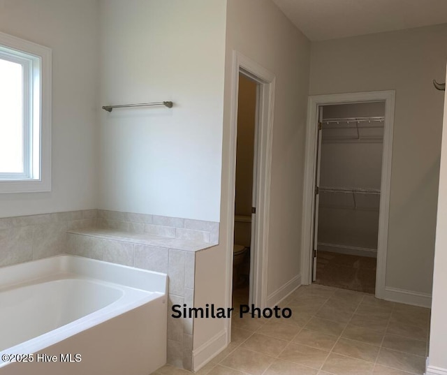 635 Indigo Johnston Dr, Jacksonville, NC 28546 - bathroom featuring a bath, a spacious closet, tile patterned floors, and toilet