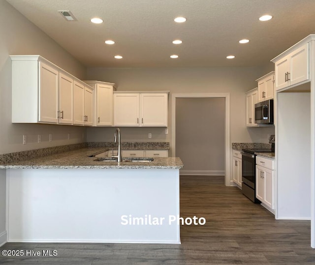 635 Indigo Johnston Dr, Jacksonville, NC 28546 - kitchen with stainless steel appliances, a sink, recessed lighting, a peninsula, and white cabinetry