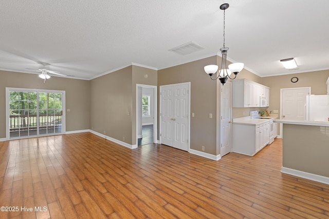 4379 Owendon Dr, Shallotte, NC 28470 - unfurnished living room with ornamental molding, ceiling fan, baseboards, light wood-style flooring, and a chandelier