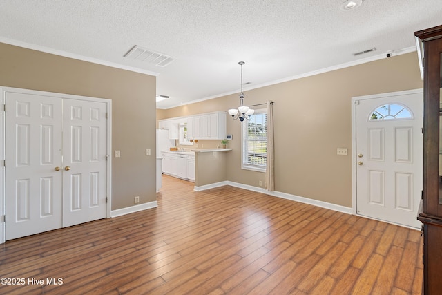 4379 Owendon Dr, Shallotte, NC 28470 - entrance foyer featuring crown molding, a textured ceiling, a chandelier, baseboards, and wood finished floors