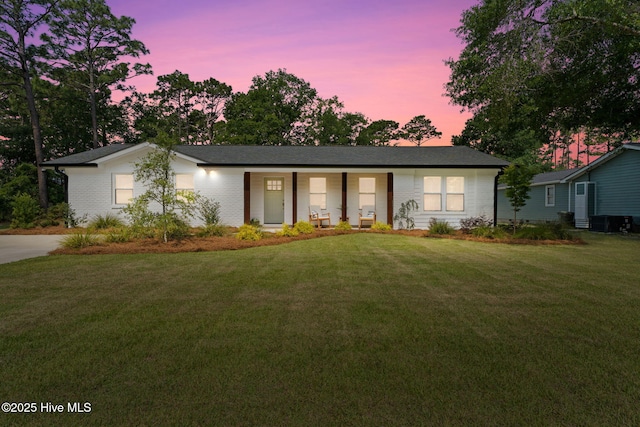 1015 E Moore St, Southport, NC 28461 - view of front of property featuring a lawn, covered porch, and brick siding