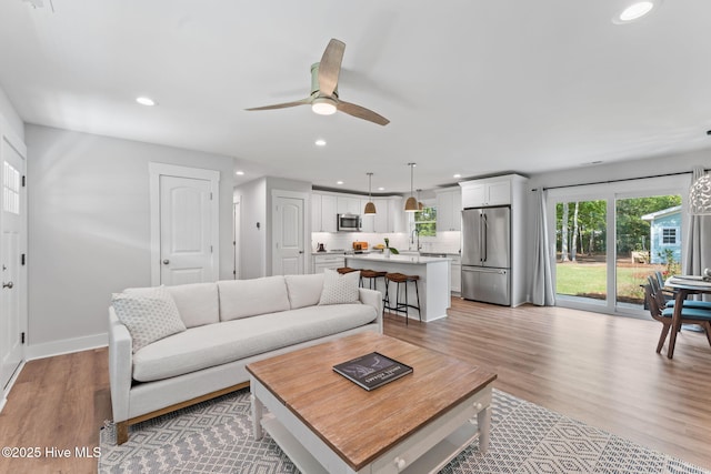 1015 E Moore St, Southport, NC 28461 - living room featuring a ceiling fan, recessed lighting, light wood-style floors, and baseboards