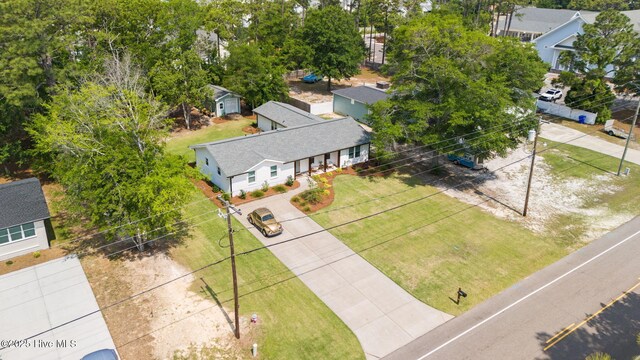 1015 E Moore St, Southport, NC 28461 - back of property at dusk with a shingled roof, a lawn, and brick siding