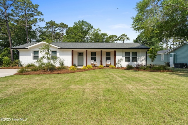 1015 E Moore St, Southport, NC 28461 - view of front facade featuring a porch, a front yard, cooling unit, and brick siding