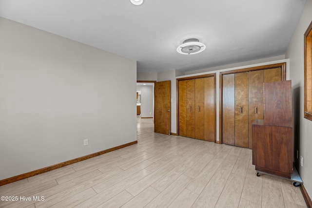 153 Windmill Point Dr, Vandemere, NC 28587 - unfurnished bedroom with multiple closets, light wood finished floors, and baseboards
