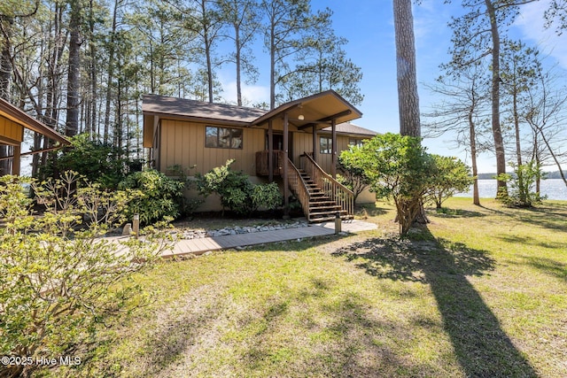 153 Windmill Point Dr, Vandemere, NC 28587 - view of front of home featuring a front lawn, a water view, and roof with shingles