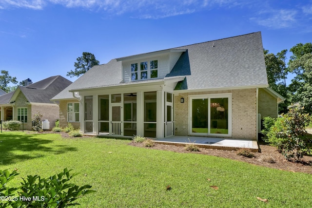 8241 Sage Valley Dr, Wilmington, NC 28411 - back of house featuring brick siding, a sunroom, a lawn, roof with shingles, and a patio