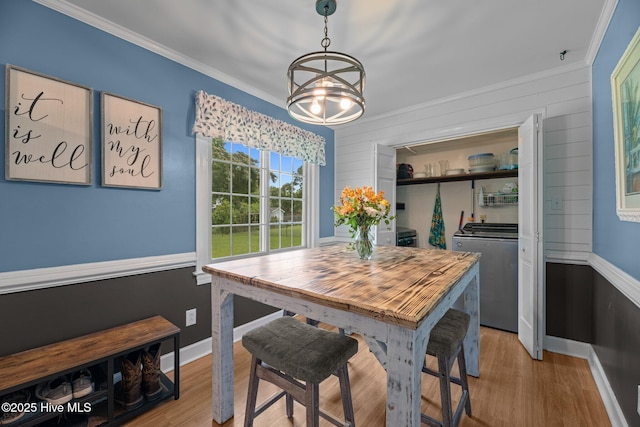 4912 Cypress Shores Dr, New Bern, NC 28562 - dining space featuring washer and dryer, crown molding, light wood-style floors, a chandelier, and baseboards