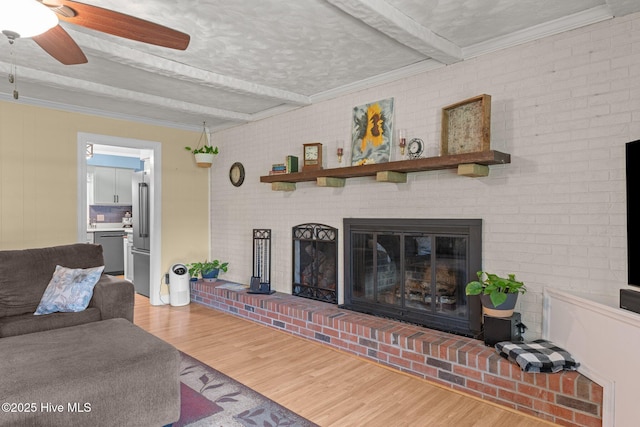 4912 Cypress Shores Dr, New Bern, NC 28562 - living room featuring beamed ceiling, wood finished floors, a ceiling fan, a fireplace, and ornamental molding
