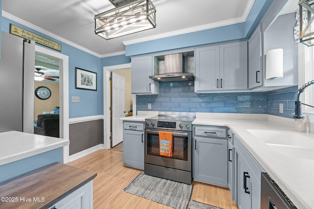 4912 Cypress Shores Dr, New Bern, NC 28562 - kitchen featuring stainless steel electric range, wall chimney range hood, backsplash, light wood-type flooring, and ornamental molding